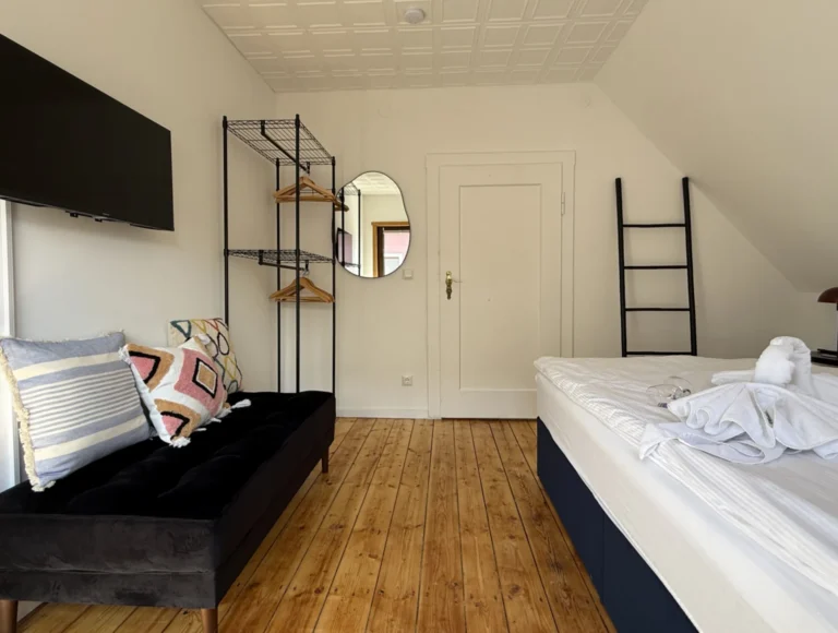 Boxspringbett und offene Kleideraufbewahrung